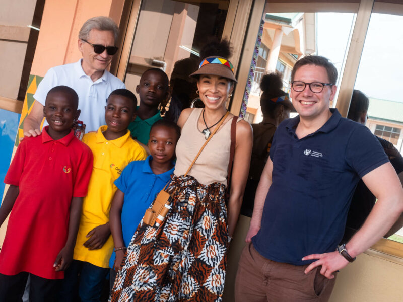 Omenaa Mensah oraz przedstawiciele WUM: Zbigniew Gaciong i Michał Grąt pozują z dziećmi z Kids Haven School